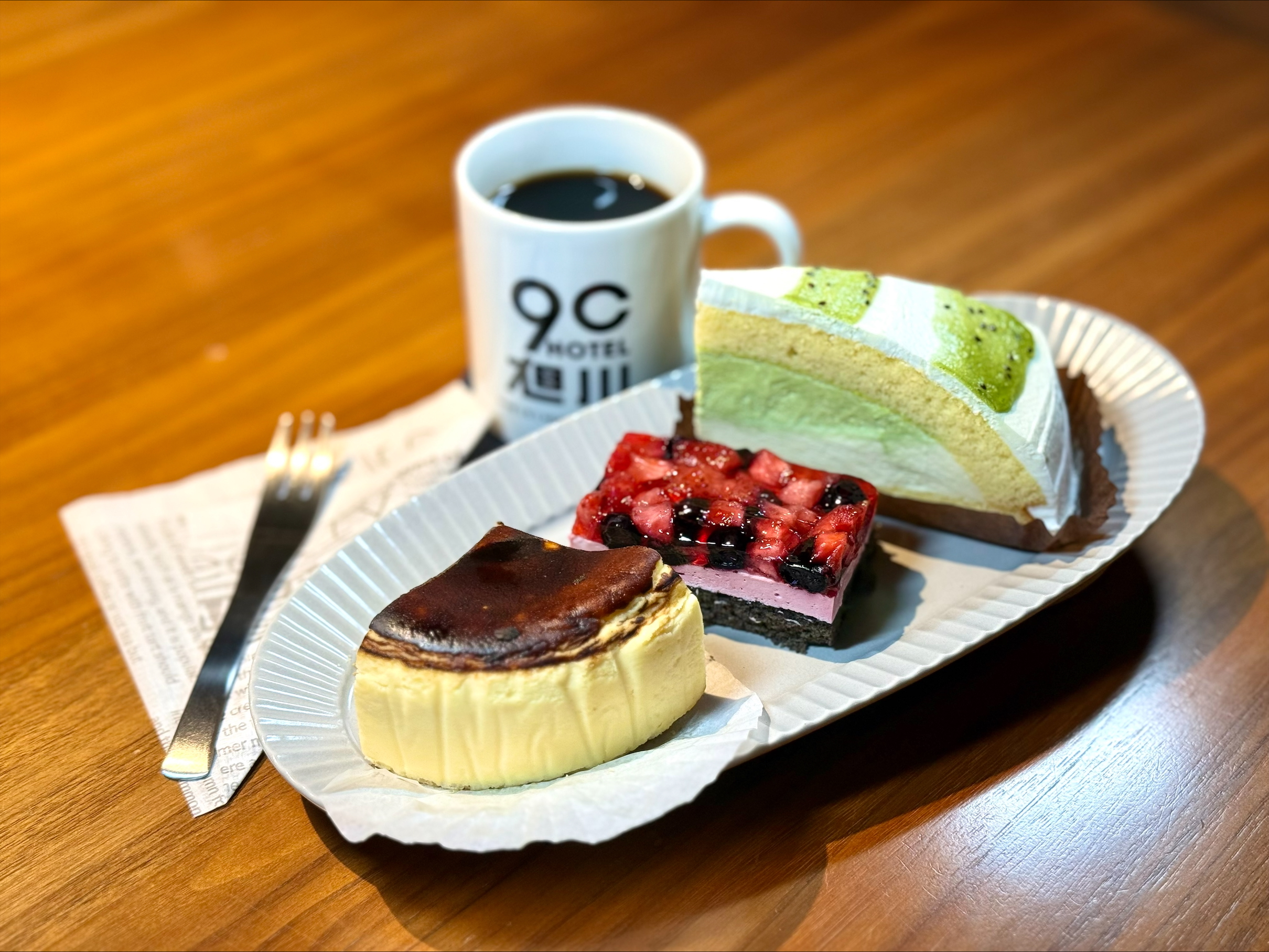9Cホテル旭川のカフェで提供される冬限定ハーフケーキプレート。キウイとバスクチーズケーキ、紫いもと洋なしケーキなどの3種類が並ぶ。